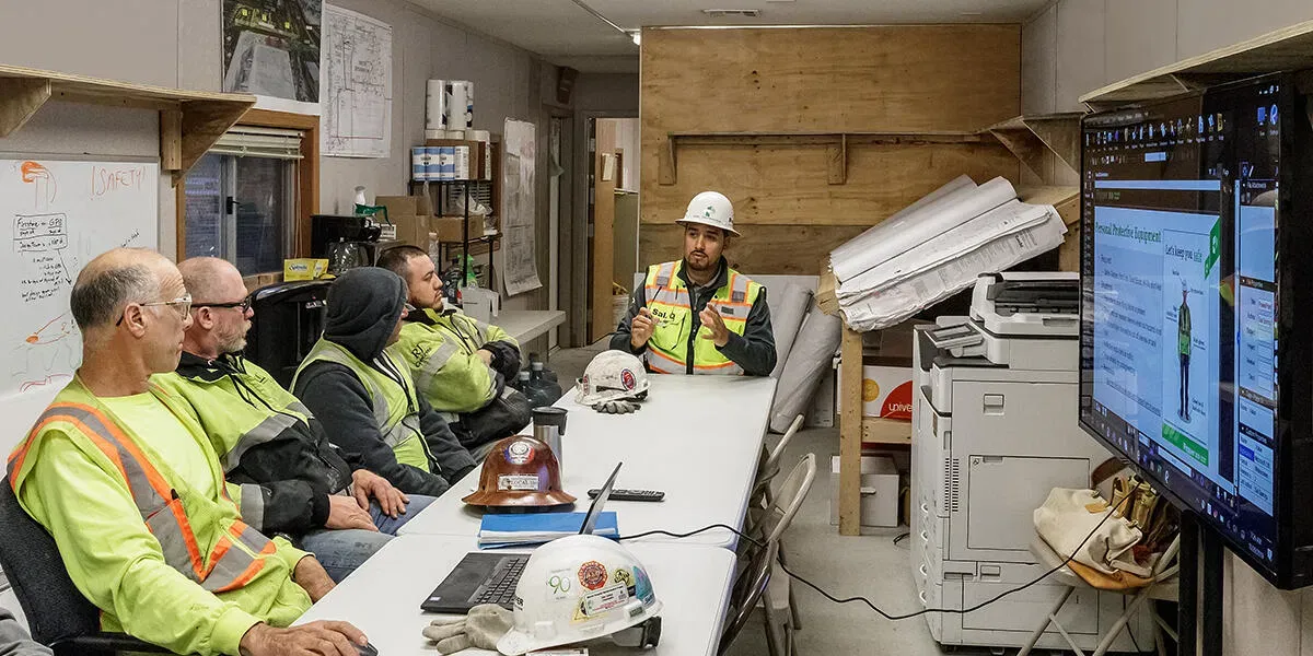 Equipe técnica acompanhando indicadores de obra em uma sala de monitoramento